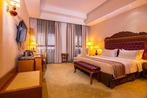 a hotel room with a large bed and a television at Royale Chulan Kuala Lumpur in Kuala Lumpur