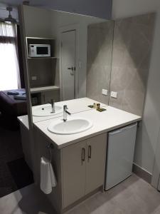 ein Bad mit einem Waschbecken und einem Spiegel in der Unterkunft Naracoorte Hotel Motel in Naracoorte