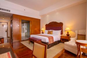 a bedroom with a large bed and a living room at Royale Chulan Kuala Lumpur in Kuala Lumpur