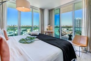 1 dormitorio con 1 cama blanca grande y ventana grande en iCoconutGrove - Luxurious Vacation Rentals in Coconut Grove, en Miami
