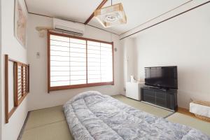 a bedroom with a bed and a flat screen tv at Shin Okubo Sekitei in Tokyo