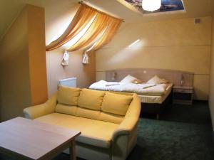 a room with two beds and a couch and a table at Hotel Wiśniewski in Kraśniów +38 photos