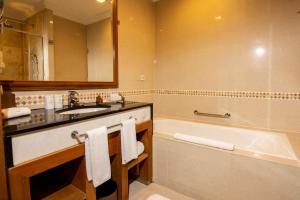 a bathroom with a tub and a sink and a bath tub at Royale Chulan Kuala Lumpur in Kuala Lumpur