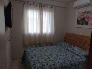 a bedroom with a bed and a window at Apto Vista Atlântico com 2 quartos com Ar Cond Wi-Fi TV SMART e Área de lazer in Itapema