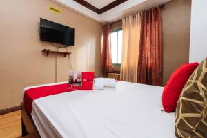 - une chambre avec un grand lit blanc et des oreillers rouges dans l'établissement RedDoorz @ Moonwalk Paranaque, à Manille