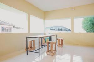 una habitación con una mesa y dos taburetes en RedDoorz near RS Imanuel Lampung, en Lampung