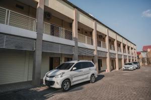 a white car parked in front of a building at RedDoorz near RS Imanuel Lampung in Lampung