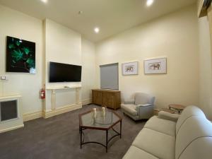 a living room with a couch and a tv at St. Elizabeth's Home in Melbourne