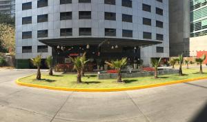 een gebouw met palmbomen ervoor bij Holiday Inn Mexico Santa Fe, an IHG Hotel in Mexico-Stad
