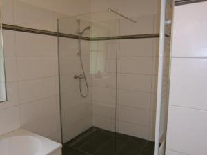 a shower with a glass door next to a toilet at Landgut Feuersang in Sankt Veit im Pongau