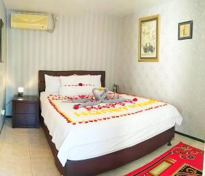 a bedroom with a large bed with a bird on it at Jos & Hanny Homestay in Batu
