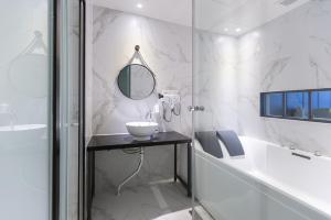Baño blanco con lavabo y espejo en Brown Dot Hotel Gyeongju, en Gyeongju