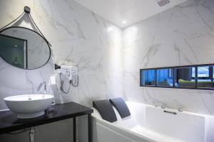 uma casa de banho branca com um lavatório e um espelho em Brown Dot Hotel Gyeongju em Gyeongju