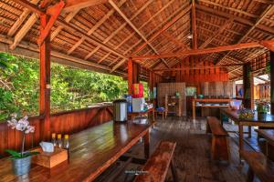 un pabellón con mesas de madera y bancos en una habitación en Hamueco Dive Resort Raja Ampat, en Rabia