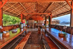 a pavilion with wooden benches and tables in a room at Hamueco Dive Resort Raja Ampat in Rabia
