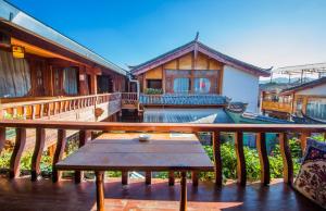 a balcony of a house with a wooden table at Lijiang Rongyi Homestay in Lijiang