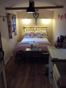 a bedroom with a large bed and a table at Llangollen Shepherds Huts in Llangollen