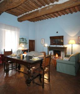 a living room with a table and a couch and a fireplace at Castello Delle Quattro Torra in Siena