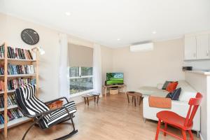 ein Wohnzimmer mit einem weißen Sofa und Stühlen in der Unterkunft Rosie's - Port Willunga - C21 SouthCoast Holidays in Aldinga Beach