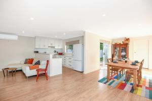 a kitchen and a living room with a table and chairs at Rosie's - Port Willunga - C21 SouthCoast Holidays in Aldinga Beach