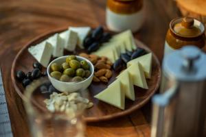 une assiette de fromage et d’autres denrées alimentaires sur une table dans l'établissement Cabo Serai, à Canacona