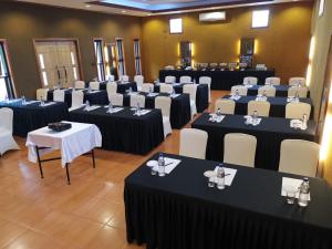 een kamer vol tafels en stoelen met zwart-witte tafels bij Spring Hill Hotel Ruteng in Ruteng