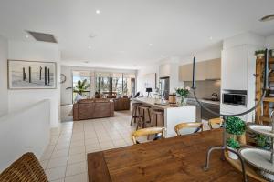 a kitchen and living room with a table and chairs at Comfy Coast Drive Condo - Free Parking - Free WIFI in Torquay