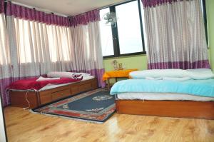 una camera da letto con due letti e una finestra di Nagarjun Home Stay a Kathmandu
