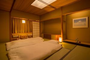 Un ou plusieurs lits dans un hébergement de l'établissement Miyajima Grand Hotel Arimoto