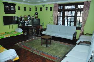 un soggiorno con un divano bianco e un tavolo di Nagarjun Home Stay a Kathmandu