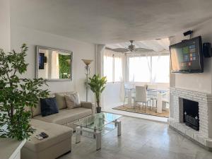 sala de estar con sofá y chimenea en Apartament Benalmadena Marina SOL, en Benalmádena