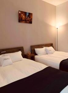 a hotel room with two beds and a picture on the wall at ひまわり 向日葵 himawari in Takamatsu