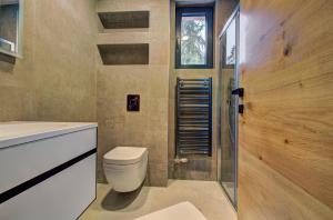Un baño con inodoro, lavabo y ducha. en Alpin Apartments Jahorina, en Jahorina 61 fotos más