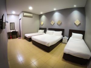 Postel nebo postele na pokoji v ubytování JV Hotel @ Bandar Tasek Mutiara