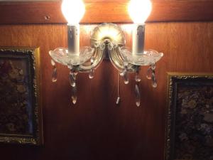 a chandelier with two candles hanging on a wall at Roulottes du Rouard in Camiers