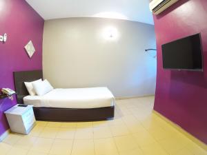 Un pat sau paturi într-o cameră la JV Hotel @ Bandar Tasek Mutiara