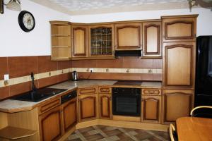 a kitchen with wooden cabinets and a sink at Dom w Bieszczadach 10 osobowy in Wołkowyja