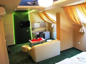 a room with a couch and a table and a green wall at Hotel Wiśniewski in Kraśniów