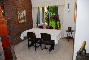 a table and chairs in a room with a brick wall at Gaerwood B&B in Keith