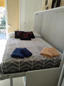 Bett mit blauen Kissen auf einem Zimmer in der Unterkunft Estudio el Retiro in Denia