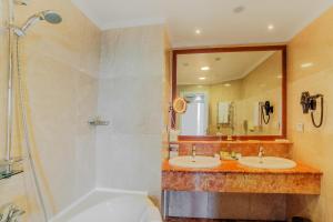 a bathroom with two sinks and a shower and a tub at Kobuleti Georgia Palace Hotel & Spa in K'obulet'i