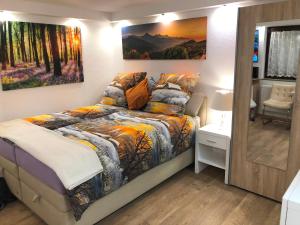 a bedroom with a bed and a painting on the wall at Ferienwohnung Apartment Dettum mit eigenem Bad, Kochnische und Wintergarten in Dettum