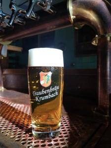 a glass of beer sitting on a machine at Hotel Gasthof Traubenbräu in Krumbach