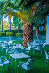 a patio area with tables, chairs and umbrellas at Hotel Balneario El Raposo in Puebla de Sancho Pérez