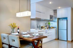 a kitchen with a wooden table and white cabinets at Shama Heda Serviced Apartment in Hangzhou