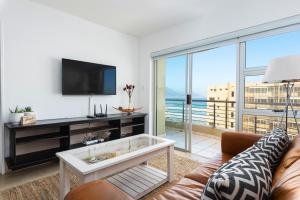 un soggiorno con divano e TV di Modern 1 Bedroom in Blouberg a Città del Capo