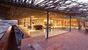 a pavilion with benches and tables on a patio at Anderssons at Ongava in Okaukuejo