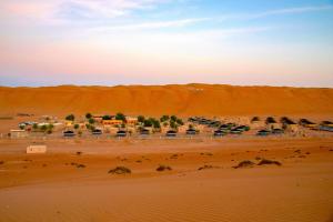um grupo de carros estacionados no deserto em Arabian Oryx Camp em Shāhiq