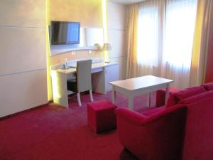 a hotel room with a desk and a table and chairs at Hotel Wiśniewski in Kraśniów