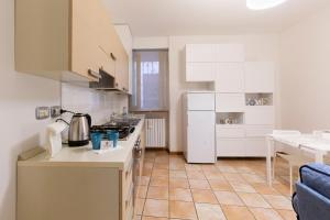 una cucina con armadi bianchi e piano di lavoro di Le Stanze di Vicolo Bonfigli a Osimo